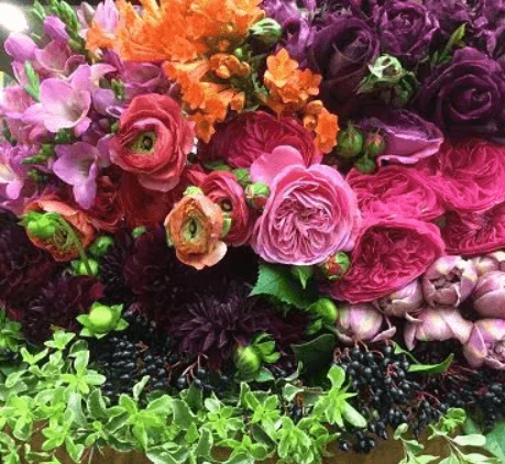 A vibrant bouquet of flowers in various colors, including pink, yellow, and purple